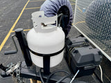 An rv rental trailer's front hitch assembly features a white propane tank, black battery box, and safety chains.