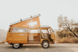 Rv rental: A sunny, orange vintage VW camper van with open pop-top & doors, ready for a road trip adventure.