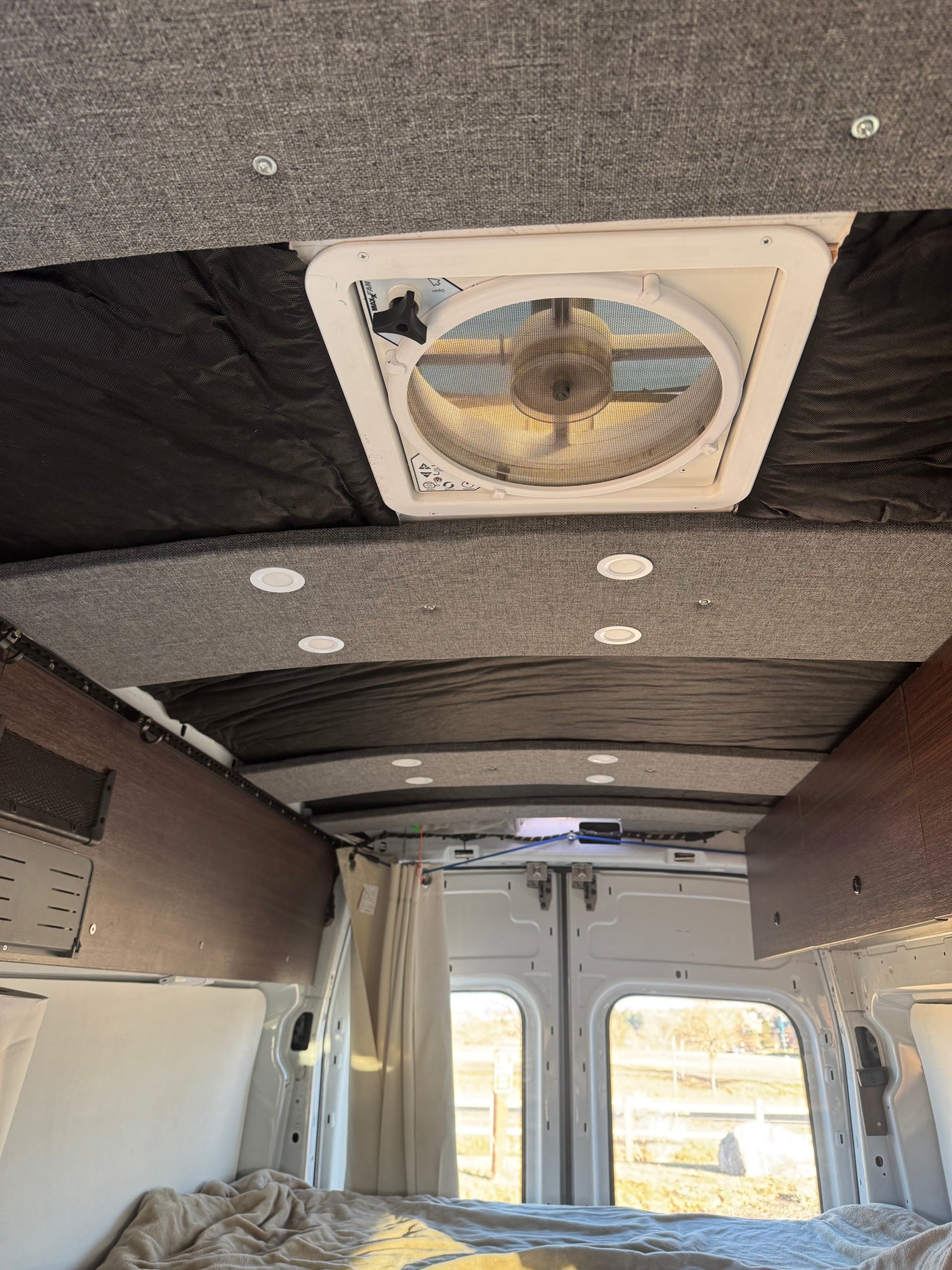 RV rental interior: cozy camper van ceiling with a fan, LED lights, and a comfortable bed for your adventures.