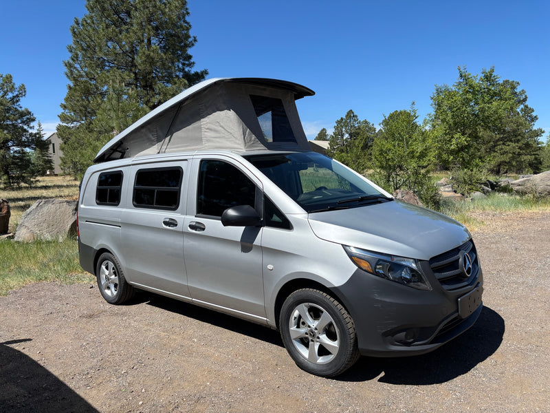 Explore with this silver Mercedes-Benz camper van, an ideal RV rental for outdoor adventures under a blue sky. — photo 1