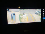 360-degree camera display for an RV rental, showing overhead view of the van, street, and a white SUV.