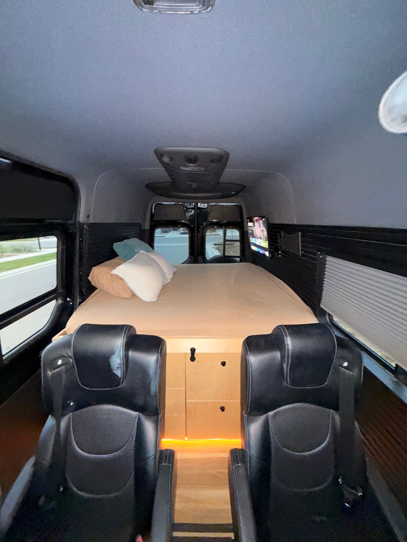 Cozy RV rental interior featuring a comfortable bed, passenger seating, and entertainment for your next adventure.