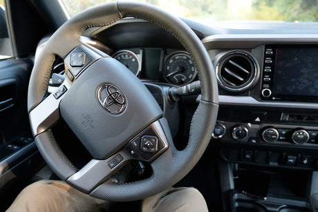 Inside a Toyota truck, a common choice for RV rental adventures, showing the steering wheel and dashboard controls.