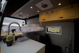Comfortable RV rental interior: bunk beds, kitchen, and overhead storage for your next adventure.