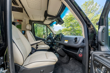 Experience luxury with this RV rental: pristine cream leather interior, spacious cabin, and tech-forward dashboard.