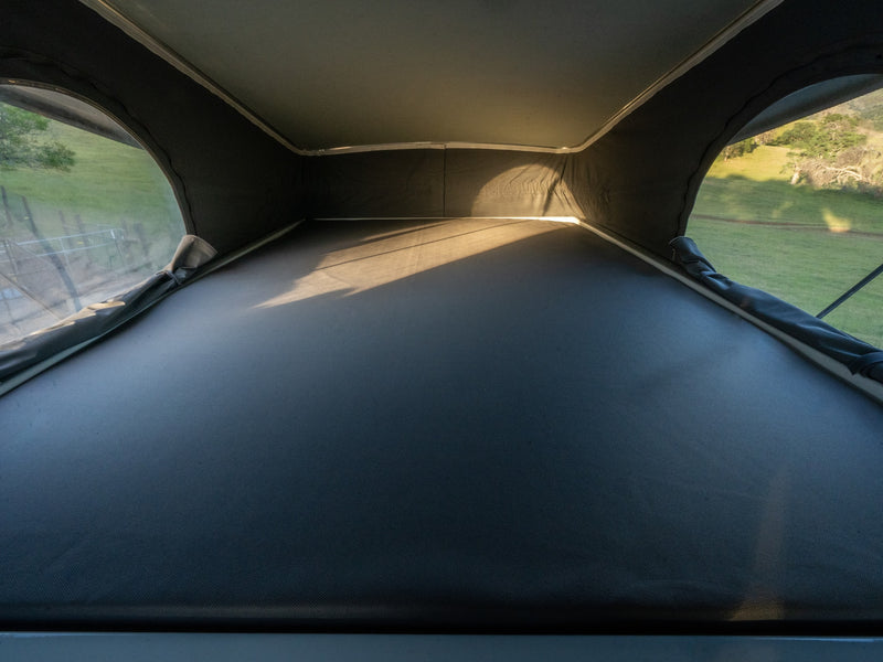 Experience an RV rental! Inside a pop-top camper's sleeping area with windows revealing sunny green outdoor views. — photo 18