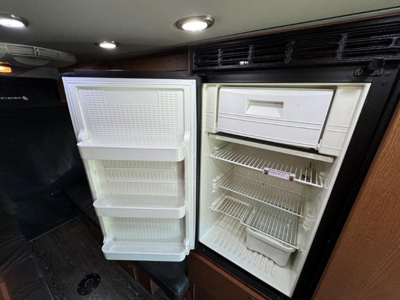  and a clear outdoor view through the screen door.|View inside an RV rental showing a functional galley with a sink — photo 12