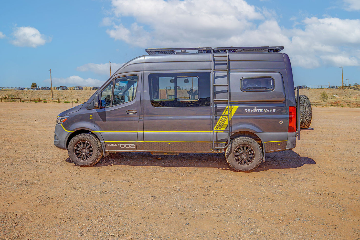 Custom grey Remote Vans adventure van with yellow details & off-road tires. Perfect RV rental for exploring.
