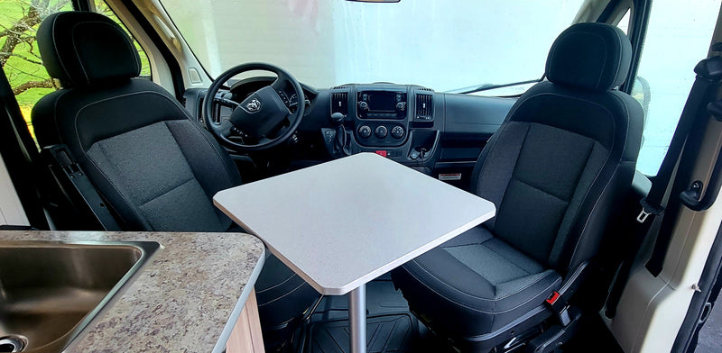 Inside an RV rental: front cabin with swiveling seats, a central table, and a kitchen sink. Perfect for camper van travel. — photo 20