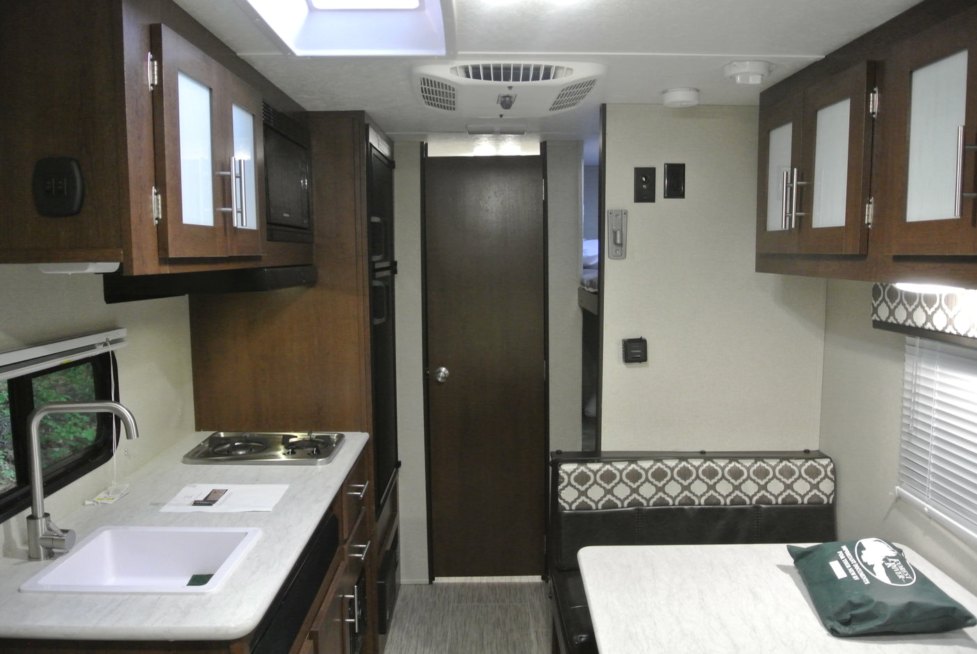 Compact RV rental interior featuring a full kitchen, dinette area, and comfortable living space for travel.