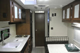 Compact RV rental interior featuring a full kitchen, dinette area, and comfortable living space for travel.