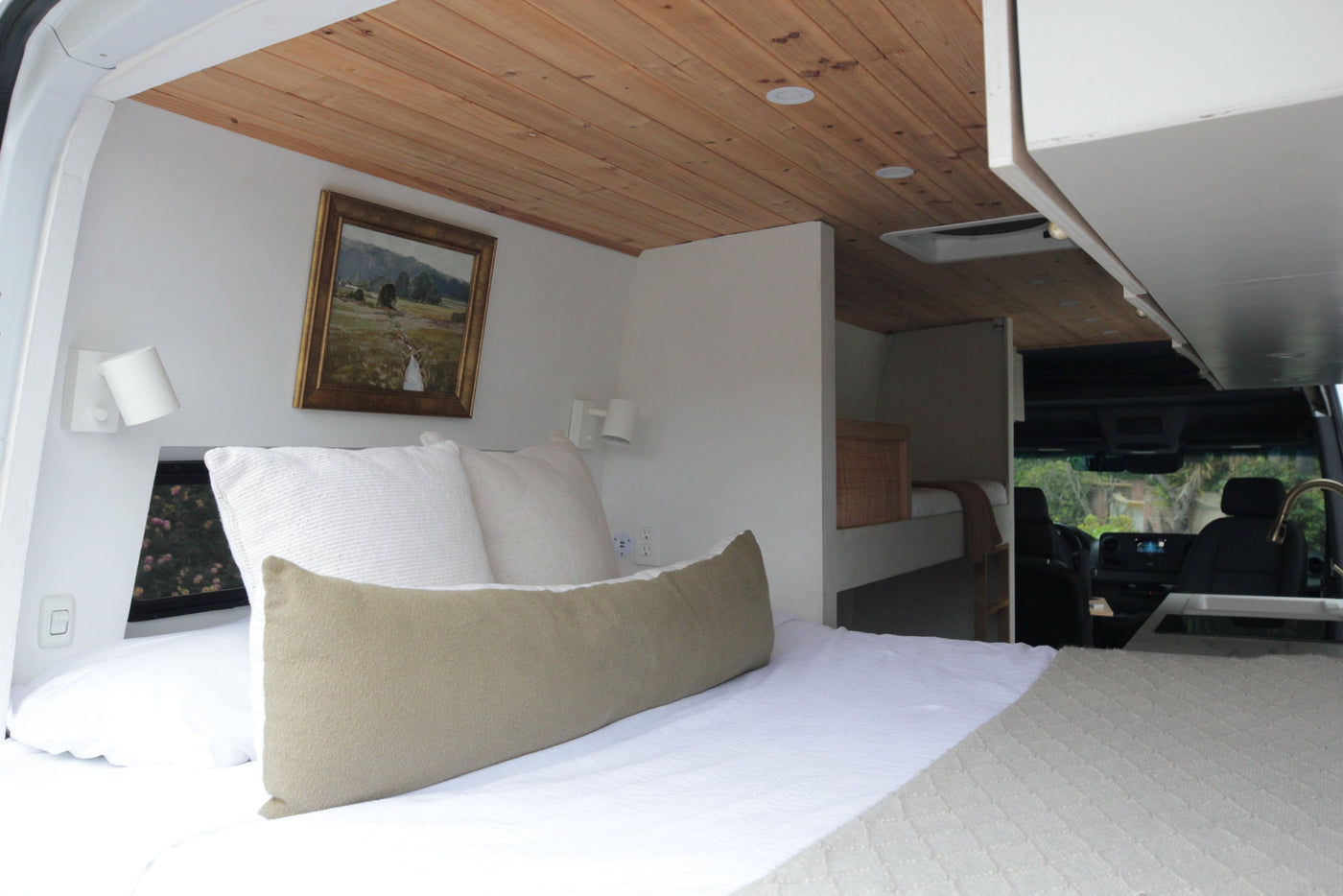 Cozy RV rental bedroom with wooden ceiling, white walls, built-in bunk, and front cabin kitchen view. — photo 7