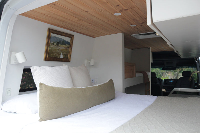Cozy RV rental bedroom with wooden ceiling, white walls, built-in bunk, and front cabin kitchen view. — photo 7