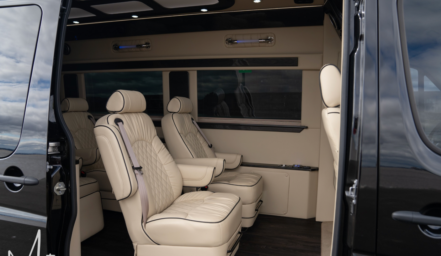 RV rental interior: luxurious & spacious, featuring cream captain's chairs with elegant diamond stitching.
