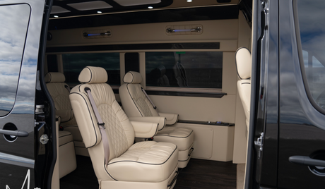 RV rental interior: luxurious & spacious, featuring cream captain's chairs with elegant diamond stitching.