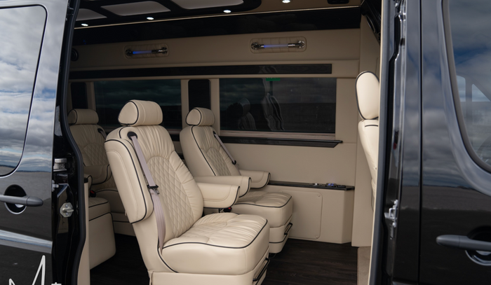 RV rental interior: luxurious & spacious, featuring cream captain's chairs with elegant diamond stitching.