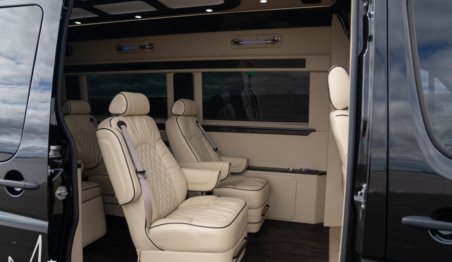 RV rental interior: luxurious & spacious, featuring cream captain's chairs with elegant diamond stitching.