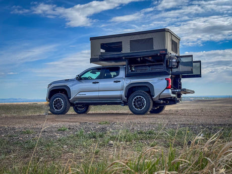  & sleeping platform setup.|Silver Toyota Tacoma overland setup with a rooftop tent and organized bed storage