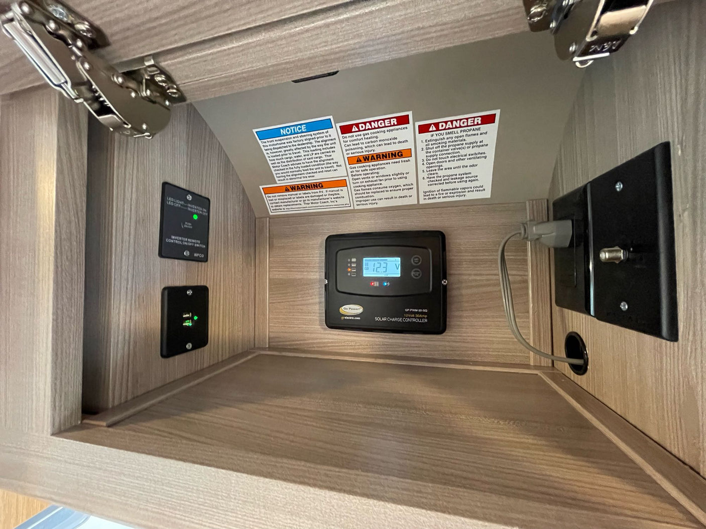 **RV rental** interior: a solar charge controller (12.3V), inverter switch, USB port, and critical safety warnings are visible.