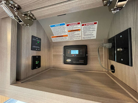 **RV rental** interior: a solar charge controller (12.3V), inverter switch, USB port, and critical safety warnings are visible.