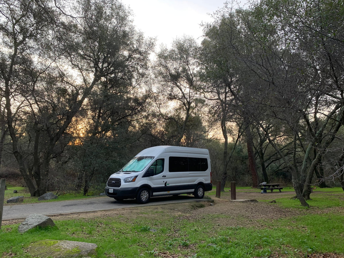 White RV rental van at a peaceful campground