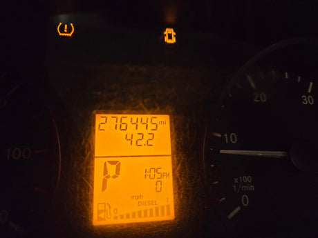 RV rental dashboard showing 276,445 miles, low tire pressure & door ajar warnings, 1:05 PM, P gear, 1/4 diesel fuel.