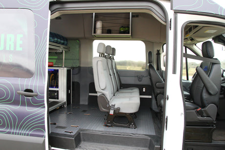 RV rental van interior: gray bench seating, custom storage, and power equipment, ready for mobile adventures.
