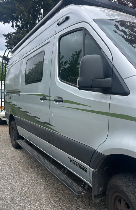 Silver Winnebago Revel adventure rv rental with distinct green decals, running boards, and a roof rack.