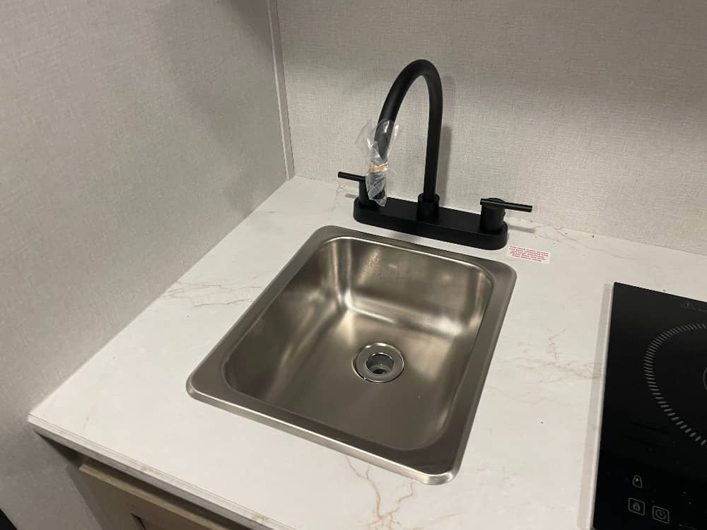 and a long bench with storage.|Cozy RV rental interior with a compact kitchen — photo 10