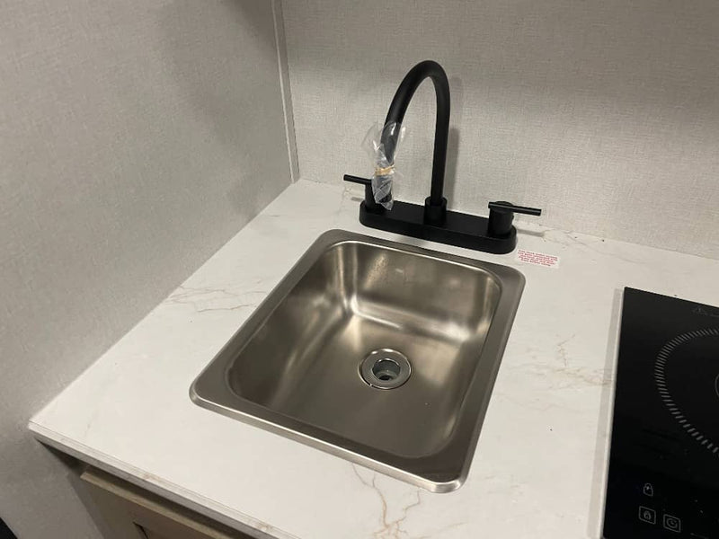  and a long bench with storage.|Cozy RV rental interior with a compact kitchen — photo 10