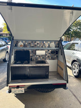 This RV rental's smart outdoor kitchen, with a stove and sink, is perfect for camping and travel adventures.
