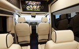 View looking forward inside a luxurious RV rental, featuring plush seating, TV, and spacious comfort.