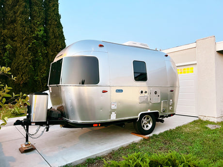 Polished Airstream travel trailer parked on concrete, perfect for an RV rental adventure. Your next camping trip awaits!