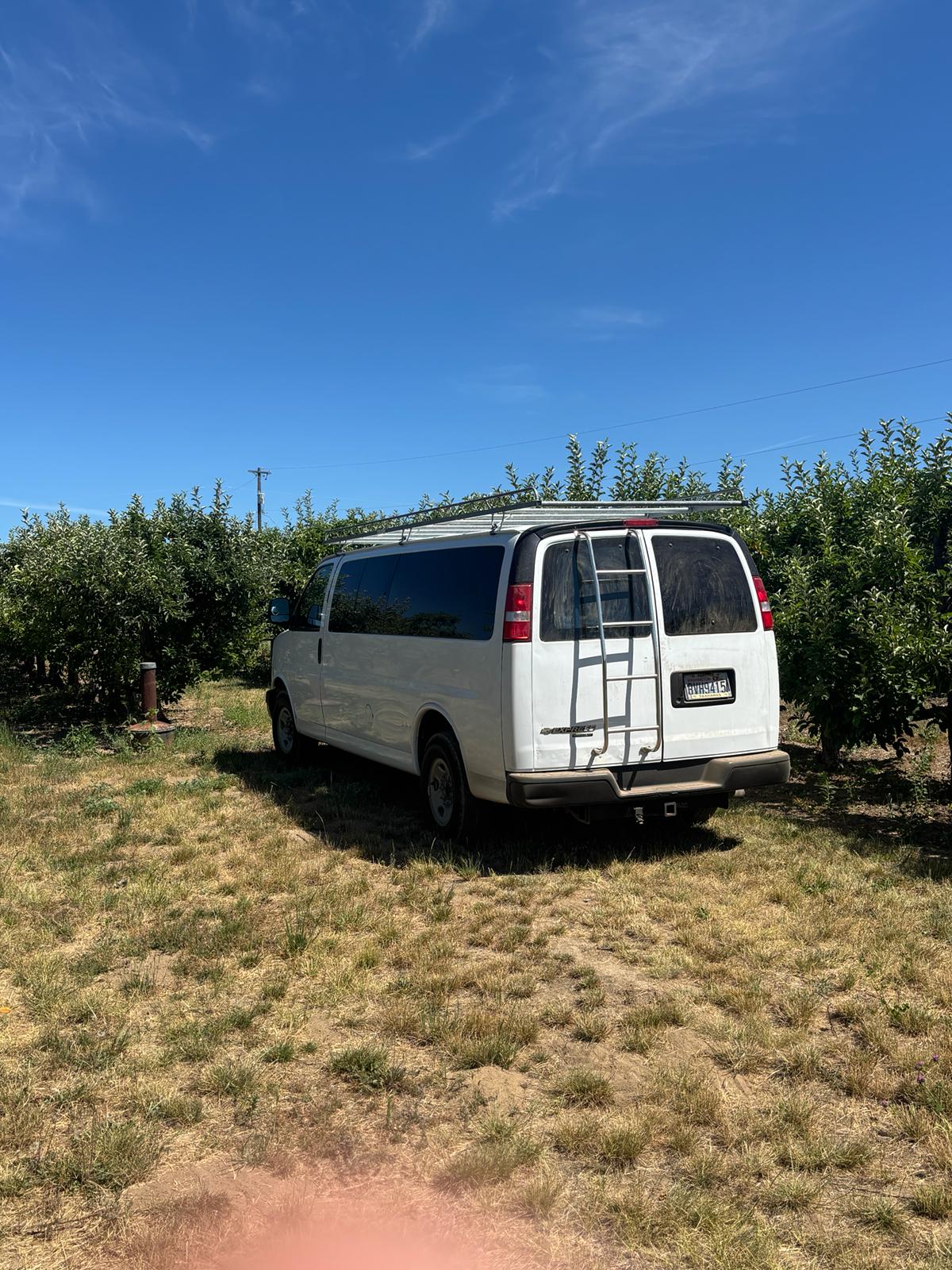  kids nearby.|White conversion van with roof rack & rear bike rack — photo 2