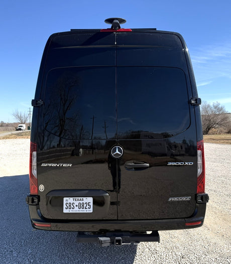 Black Mercedes-Benz Sprinter camper van, ideal for rv rental. Rear view showing Texas plate SBS * 0825 and hitch.