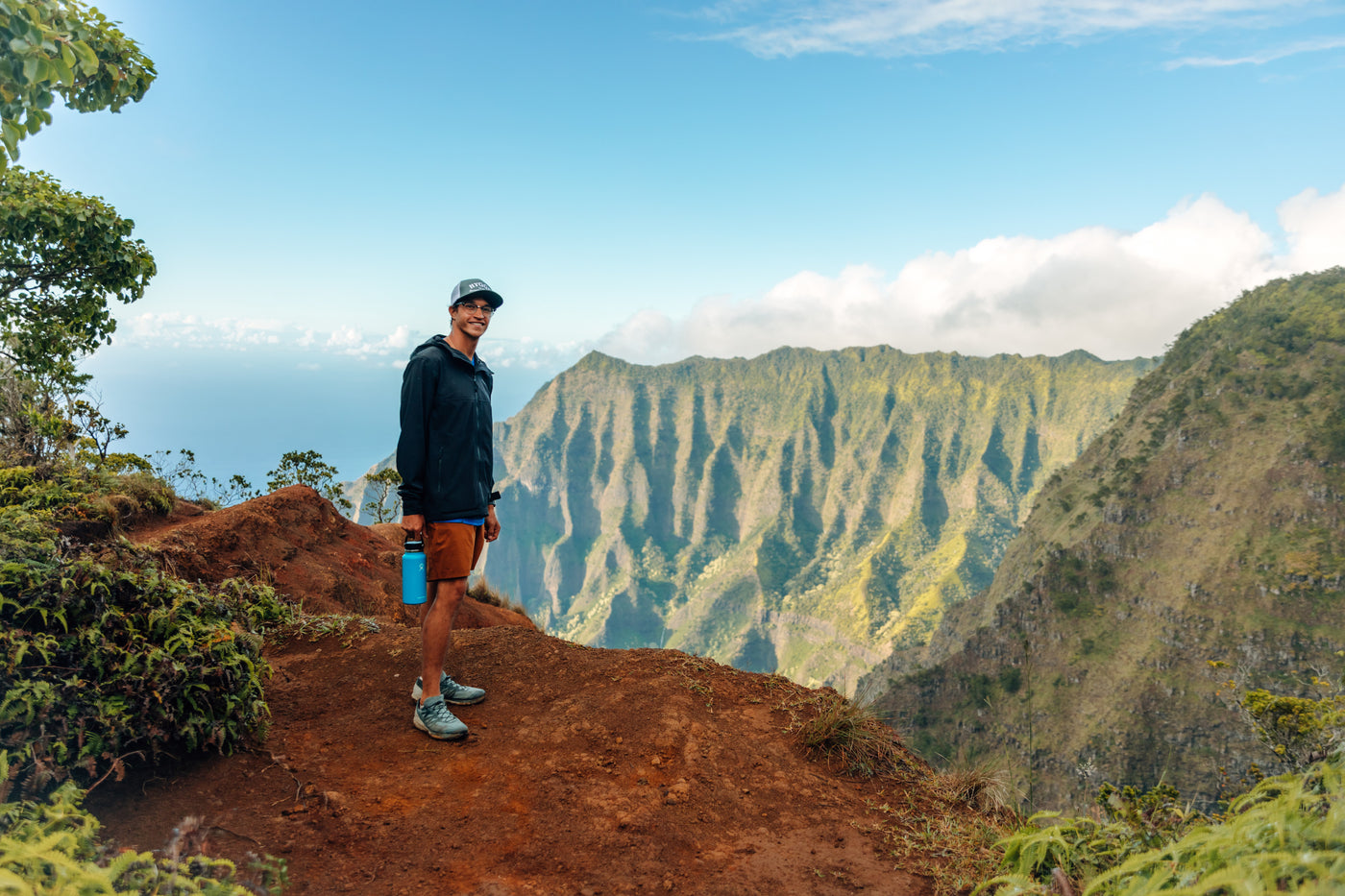 Man with a water bottle at a stunning mountain overlook, a great RV rental adventure spot with ocean views. — photo 6