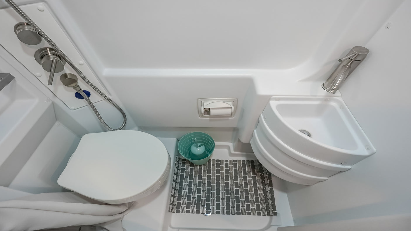 This rv rental wet bath features a space-saving toilet, corner sink, and shower for your travels.