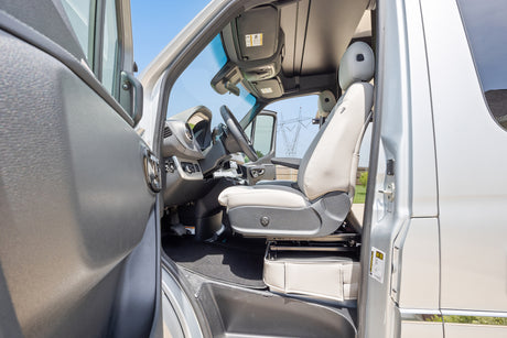 RV rental: Driver's seat and interior of a camper van with open door.