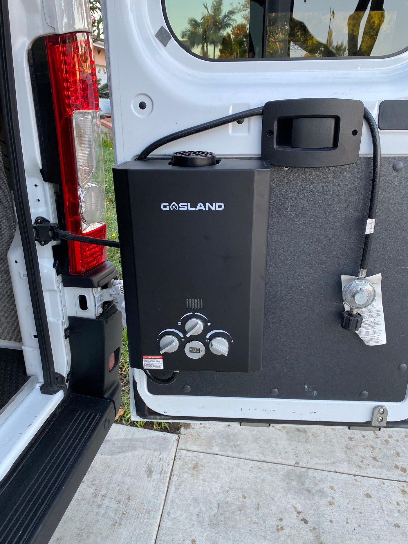Portable GASLAND water heater installed in an RV rental van, ideal for outdoor showers.