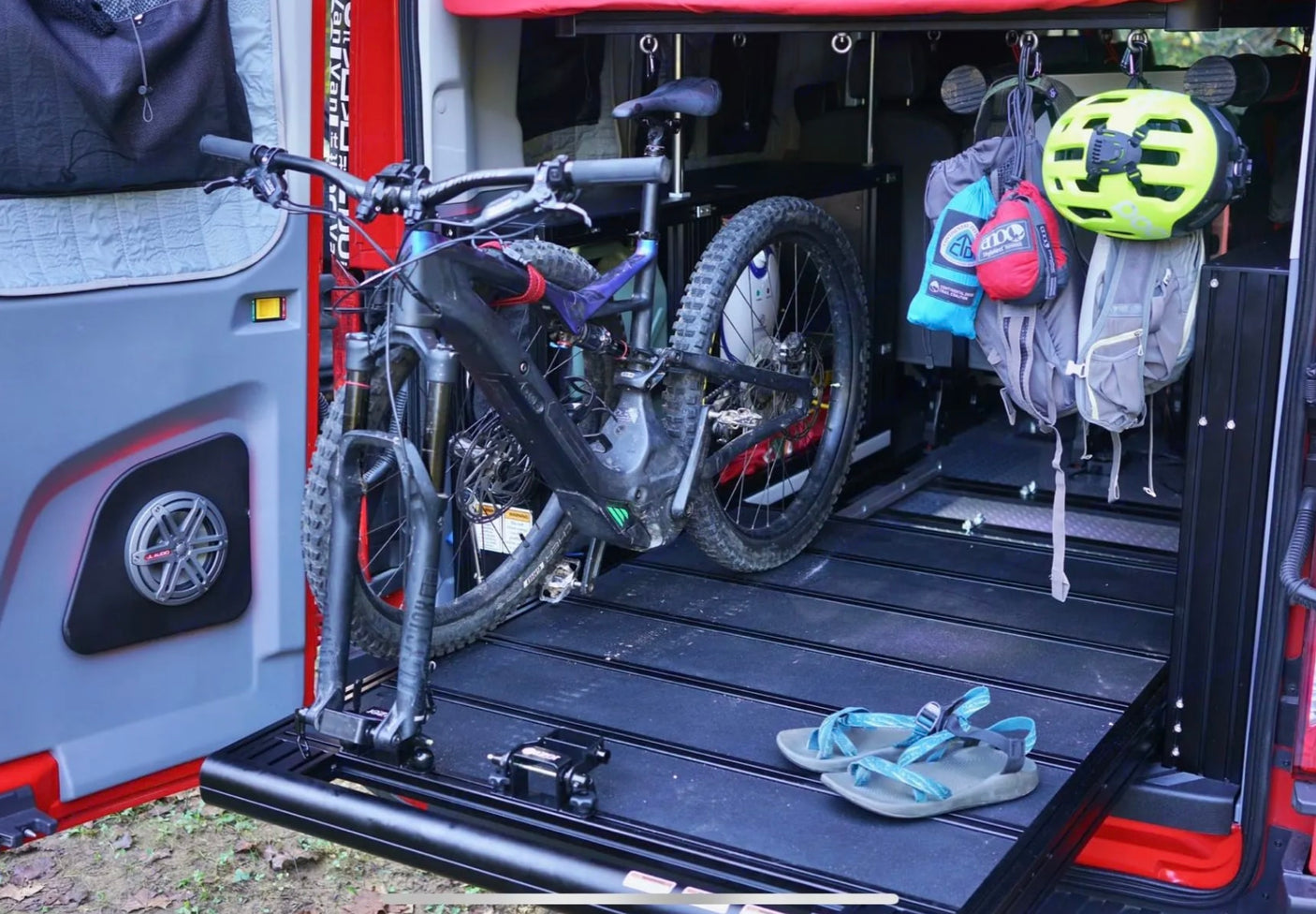RV rental adventure: Mountain bike secured on a pull-out tray, gear hanging in a custom van.