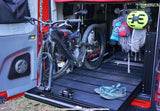 RV rental adventure: Mountain bike secured on a pull-out tray, gear hanging in a custom van.