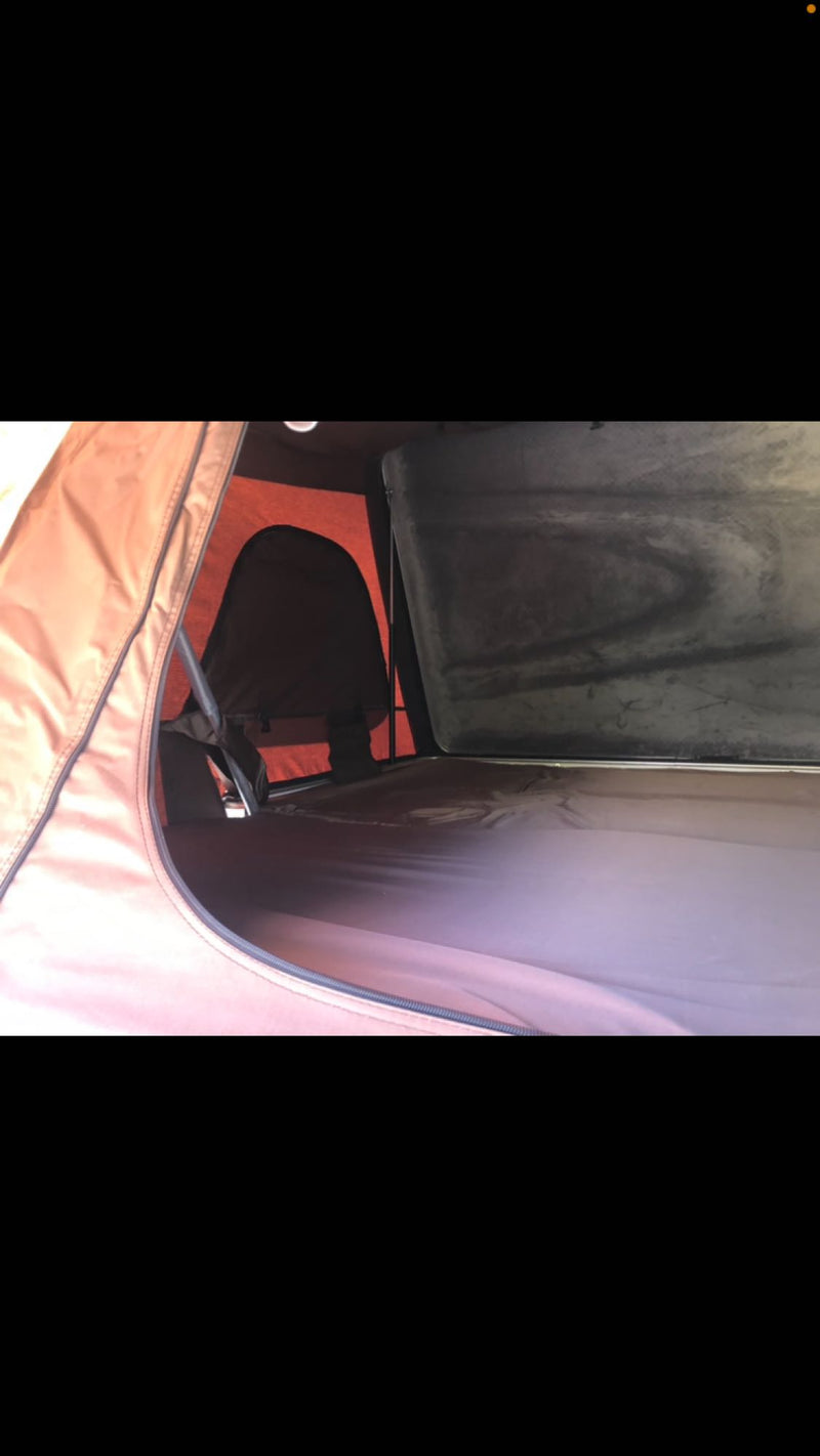  and stove on gravel at a campsite.|This image shows a white mattress and pillows inside a vehicle — photo 15