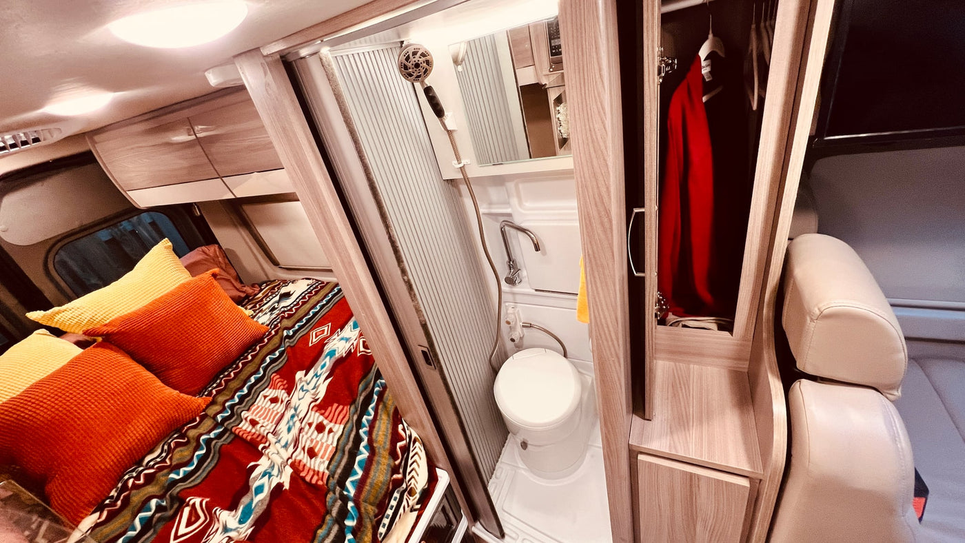  and ladder. Golden sunlight fills this cozy mobile living space.|Cozy RV rental bed with a colorful Southwestern-style blanket — photo 12