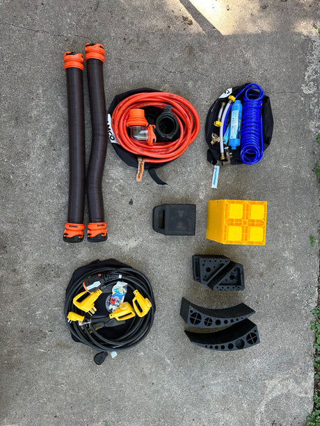 Essential RV rental gear: sewer & water hoses, power cords, filters, and leveling blocks for a smooth trip.