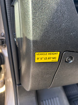 Yellow 'VEHICLE HEIGHT' sticker in an RV rental: 9' 5" (2.87 M), vital for clearances.