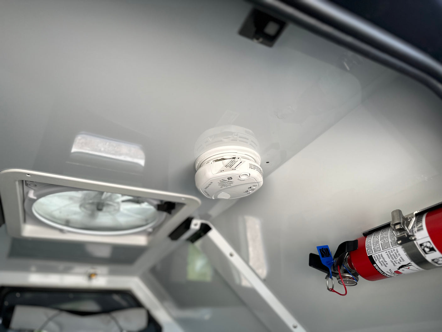 Essential RV rental safety: A smoke detector, fire extinguisher, and ceiling vent fan installed for occupant protection.