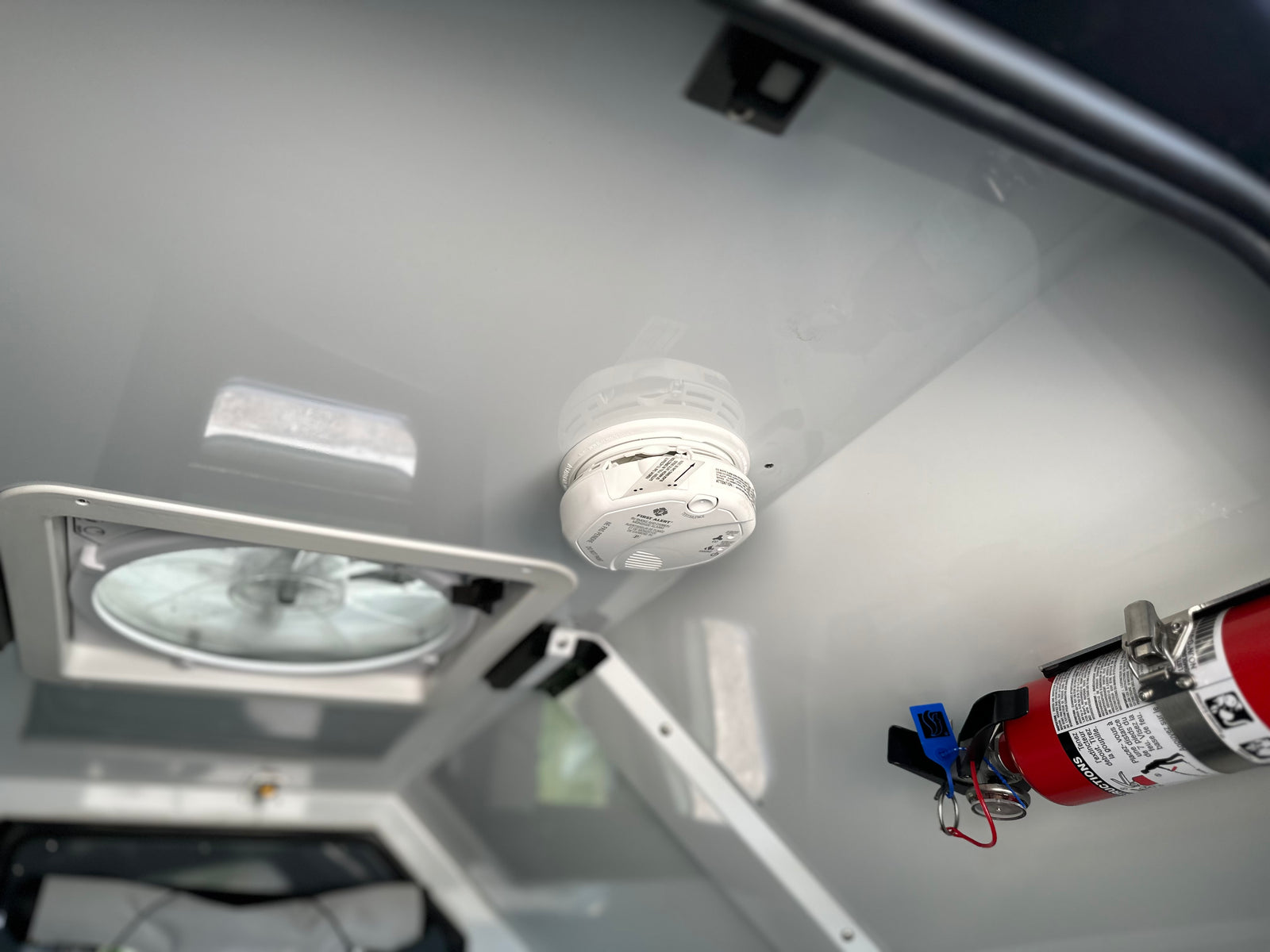 Essential RV rental safety: A smoke detector, fire extinguisher, and ceiling vent fan installed for occupant protection.