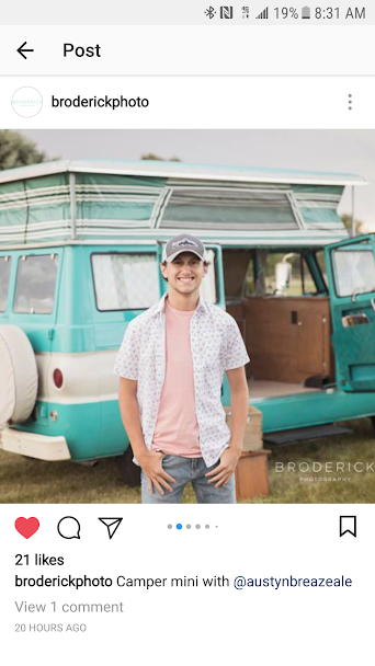 A young man poses by a retro turquoise camper van, ideal for RV rental. A broderickphoto portrait.