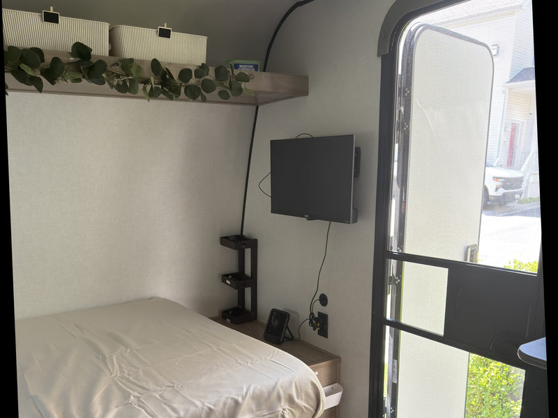  and small kitchen setup. Perfect for your next adventure!|RV rental interior: window with tree view & EMERGENCY EXIT — photo 4