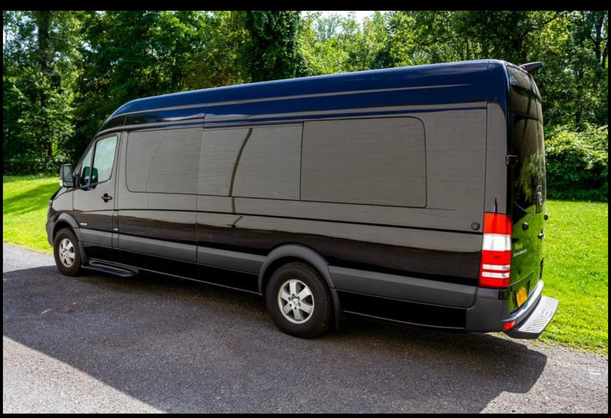 Sleek black Mercedes Sprinter van, available for RV rental, parked. Its long body, privacy tinted windows, and rear step are visible.